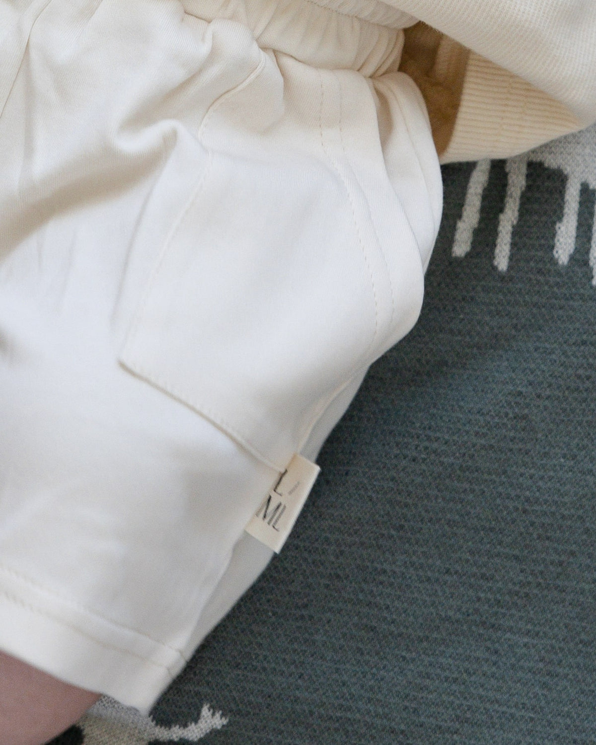 Close-up of the elastic waistband and drawstring on beige shorts